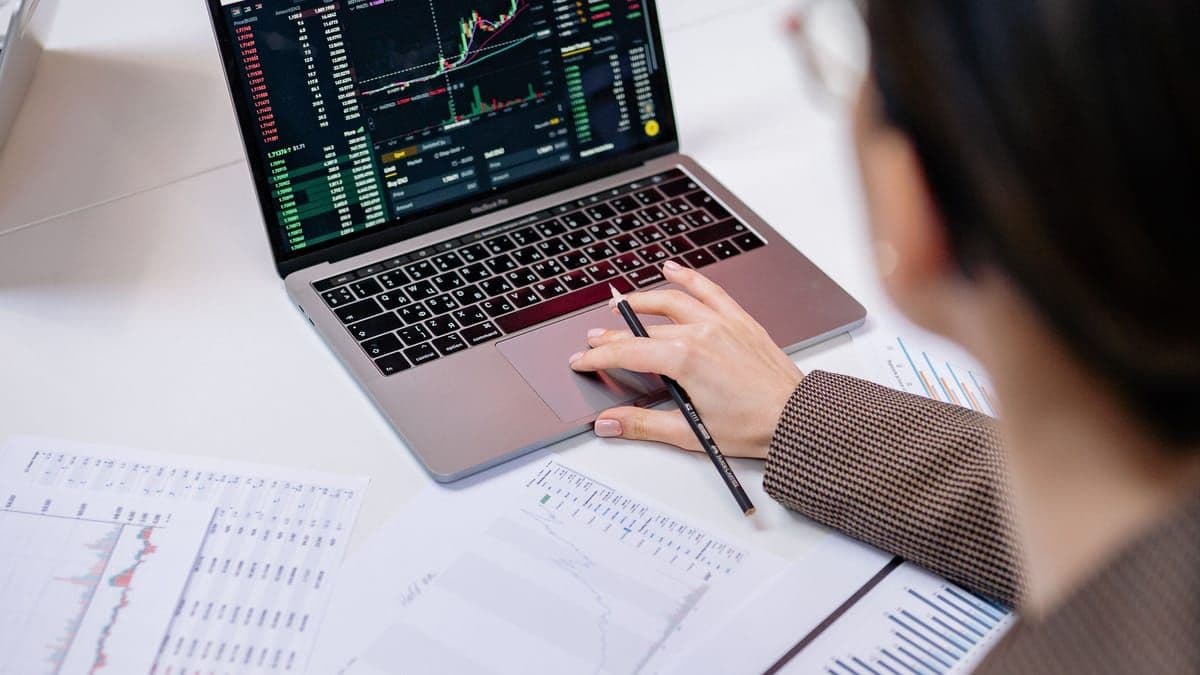 A person analysing stock-market charts on a laptop