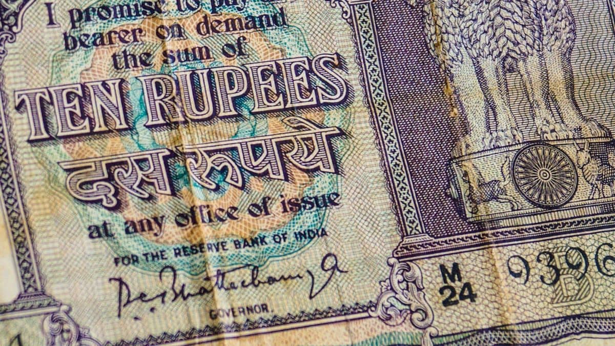 A vintage Indian ten-rupee banknote on a dark background