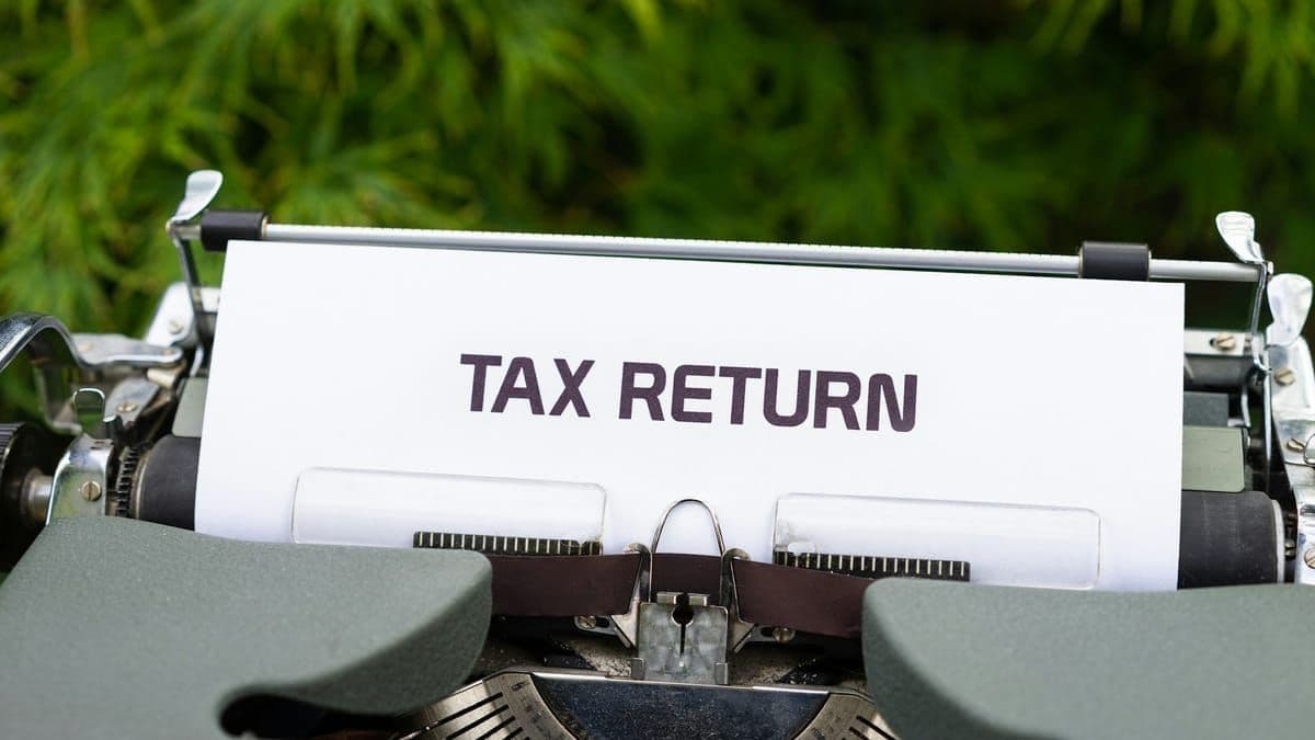 A close-up of a vintage typewriter with a sheet of paper reading TAX RETURN