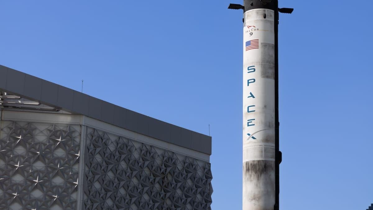 A SpaceX Falcon 9 rocket on display against a clear blue sky in Dubai